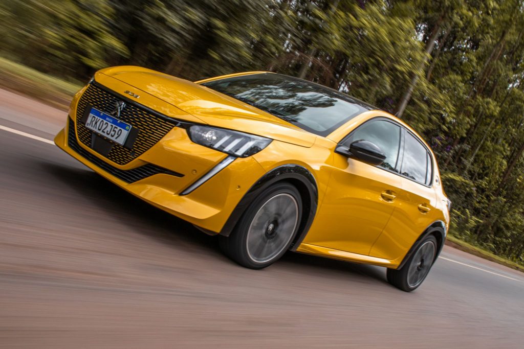 Peugeot e-208 elétrico amarelo de frente em movimento.