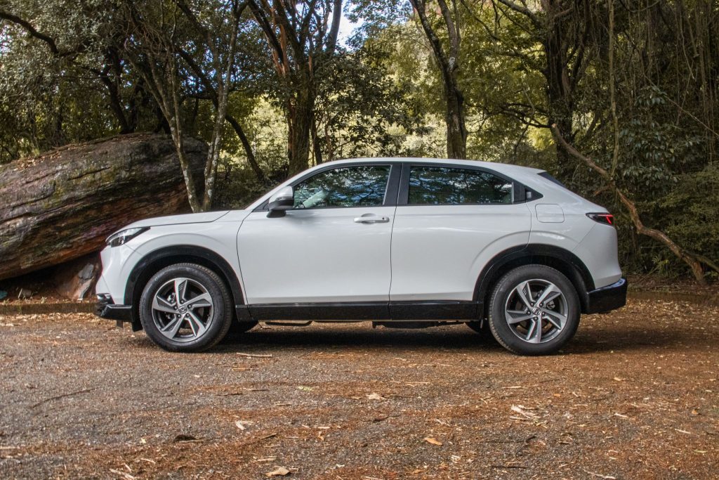 Honda HRV Touring turbo branco estacionado de lado.