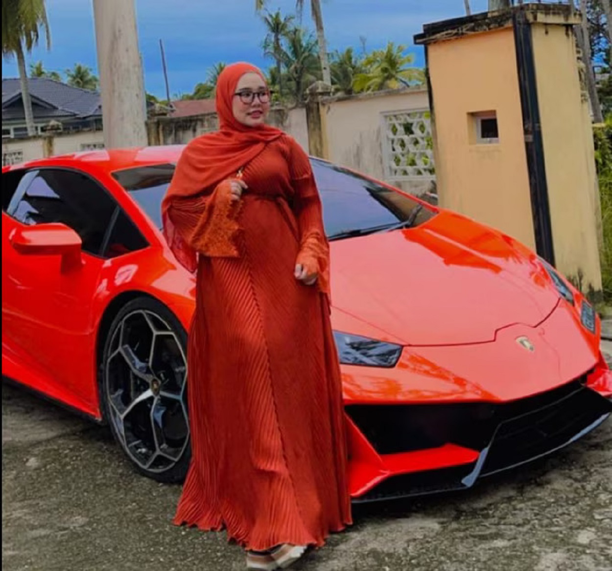 Mãe da menina que ganhou o G63 de presente. A mulher está posando na frente de um Lamborghini Huracán Evo.