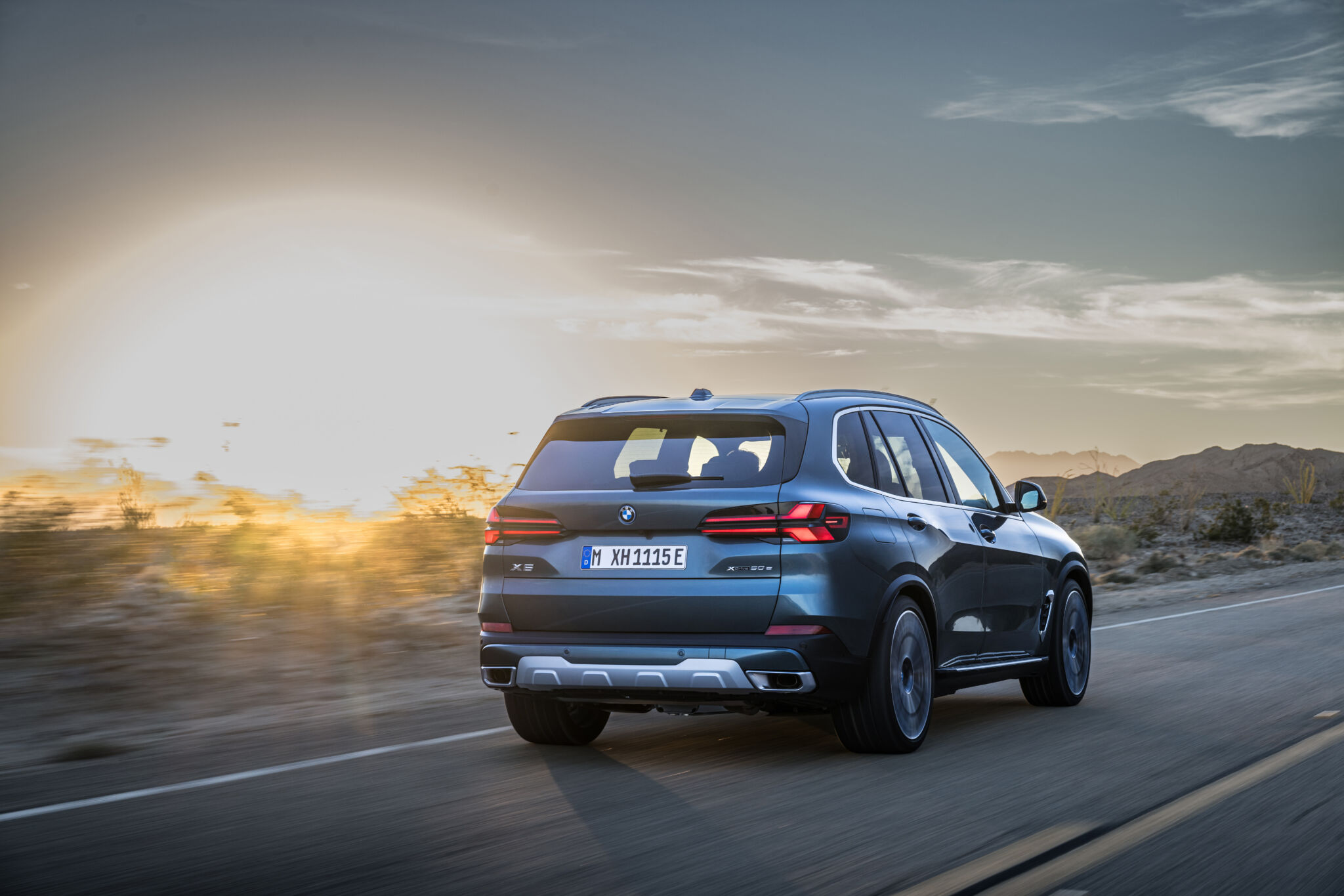 Novo BMW X5 visto de trás em movimento na estrada.