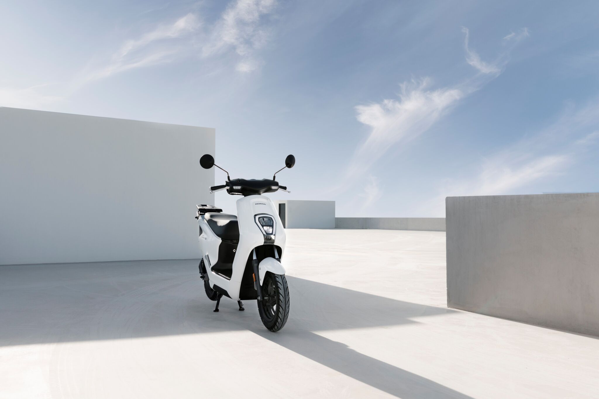 Moto elétrica Honda EM1 e branca de frente