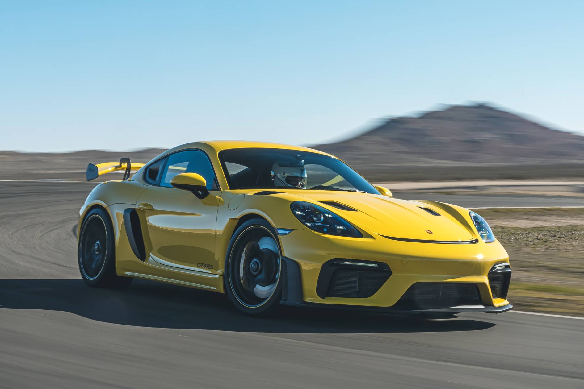 Porsche 718 Cayman GT4 RS amarelo de frente fazendo curva