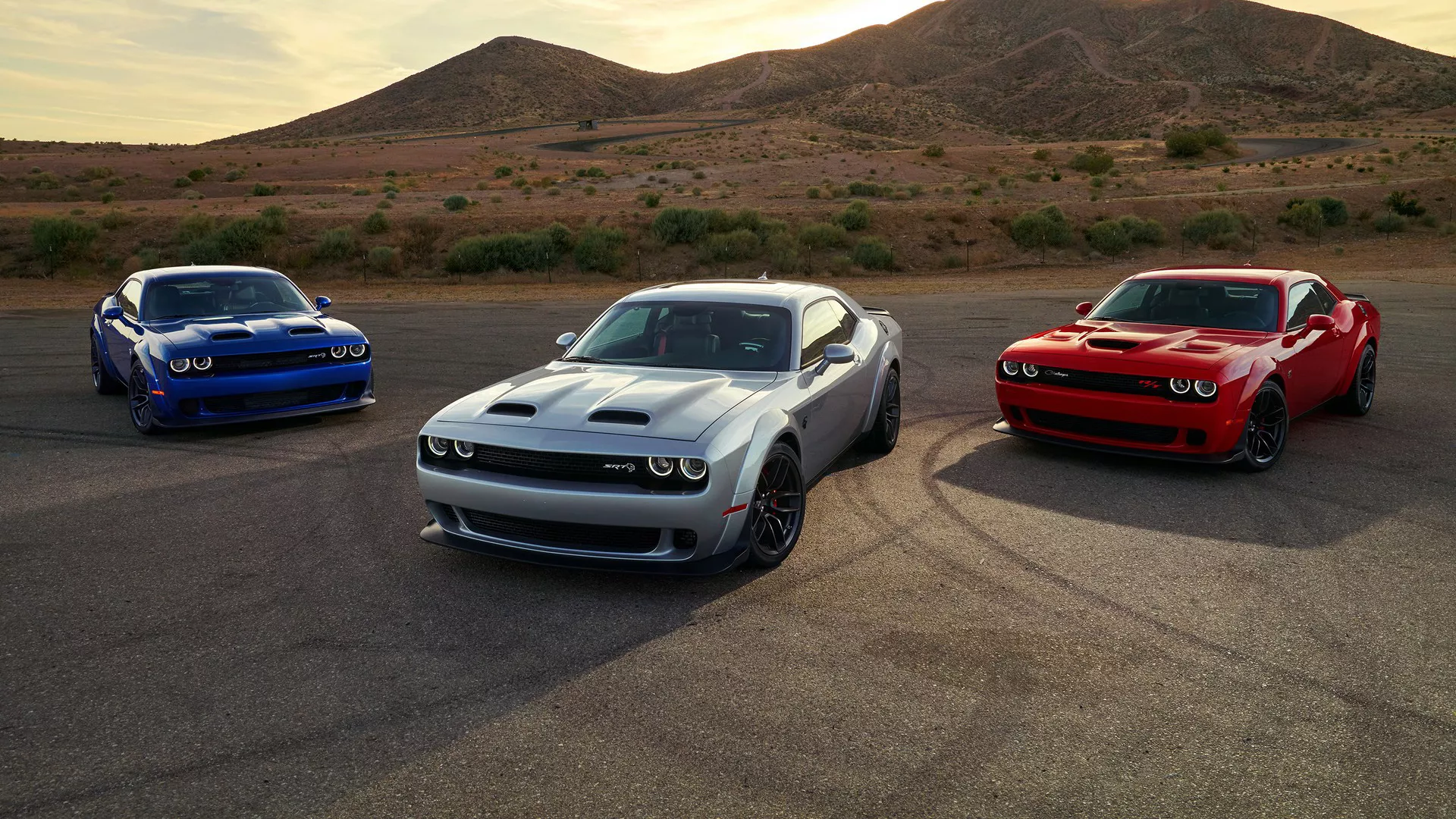 Dodge Challenger azul ao fundo, branco no centro e vermelho na lateral direita; para matéria sobre roubo de carros