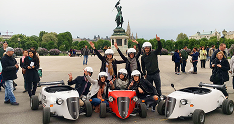 Sete turistas posam para a foto durante o tour diurno com três mini carros hotrod.