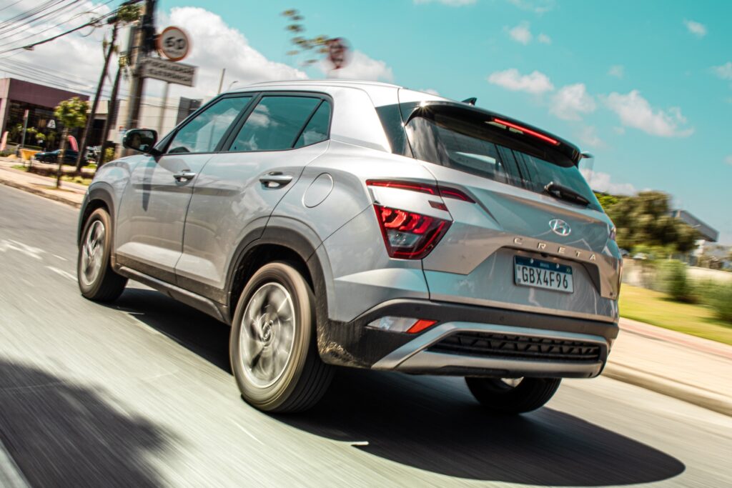 hyundai creta 1.0 turbo modelo 2021 segunda geracao prata de traseira em movimento no asfalto