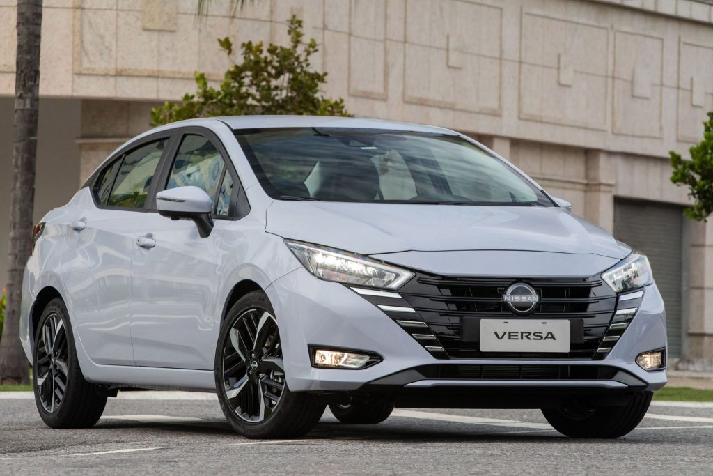 Nissan Versa 2024 de frente estacionado, sedã foi reestilizado.