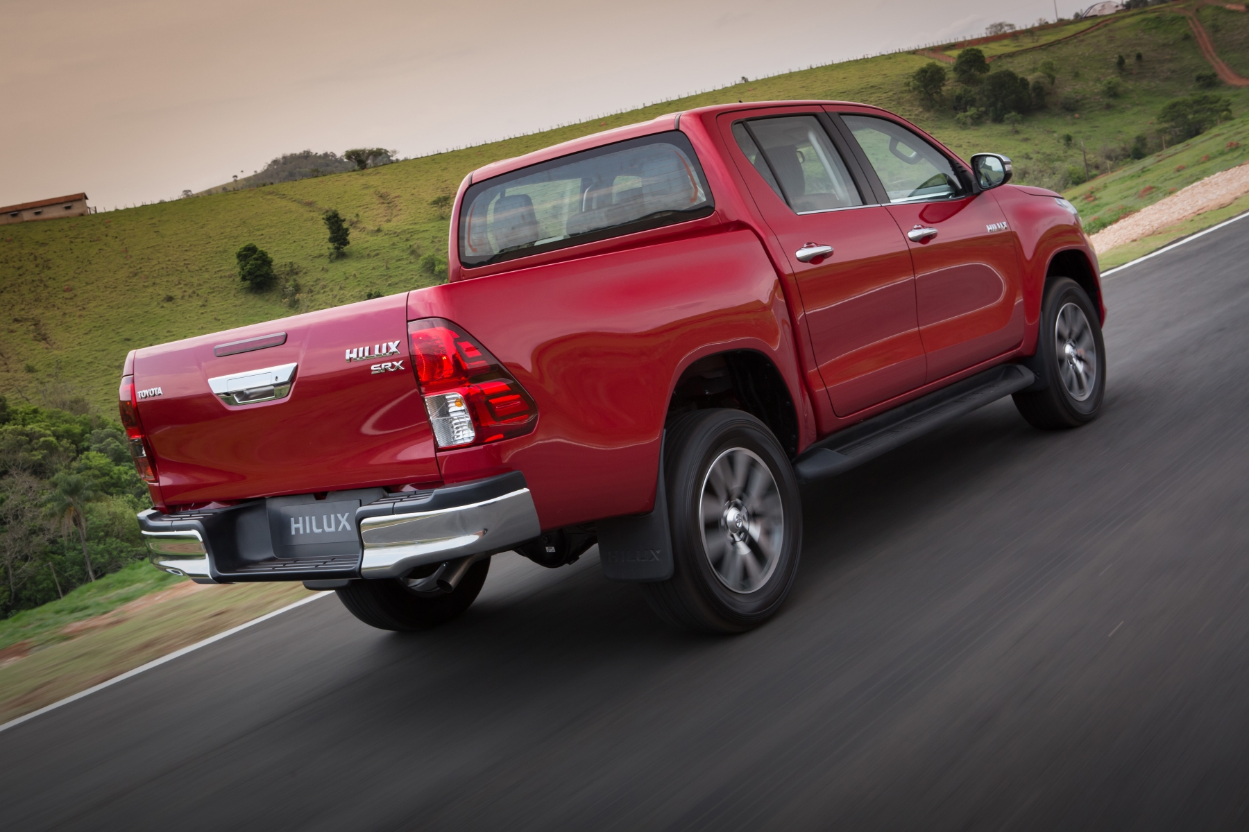 toyota hilux srx modelo 2015 vermelha de traseira em movimento no asfalto