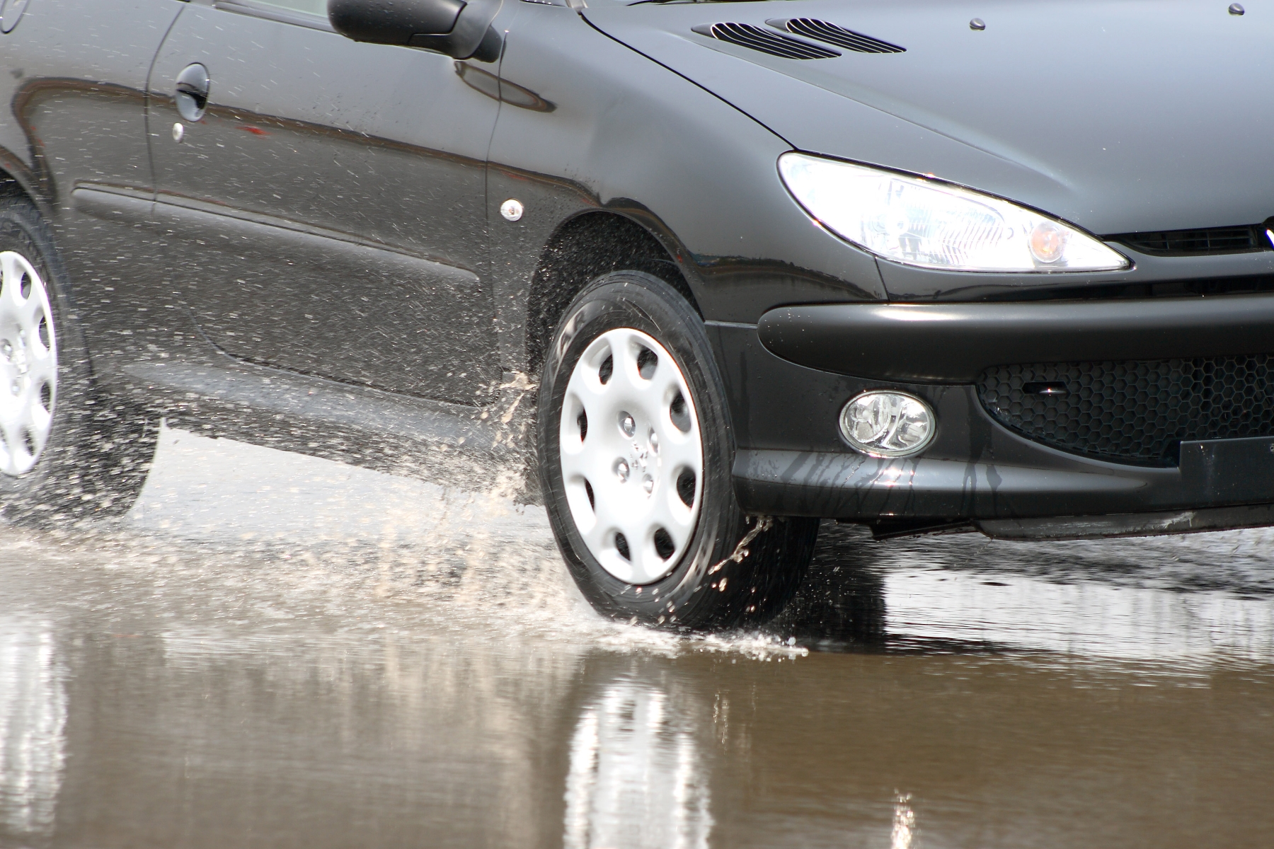 aquaplanagem pneus trafegando sobre pista molhada com spray de agua no asfalto