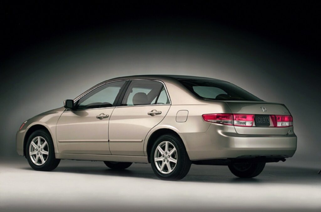 Honda Accord 2003 em tom bronze visto da diagonal traseiro. Este é o modelo utilizado pelo milionário.