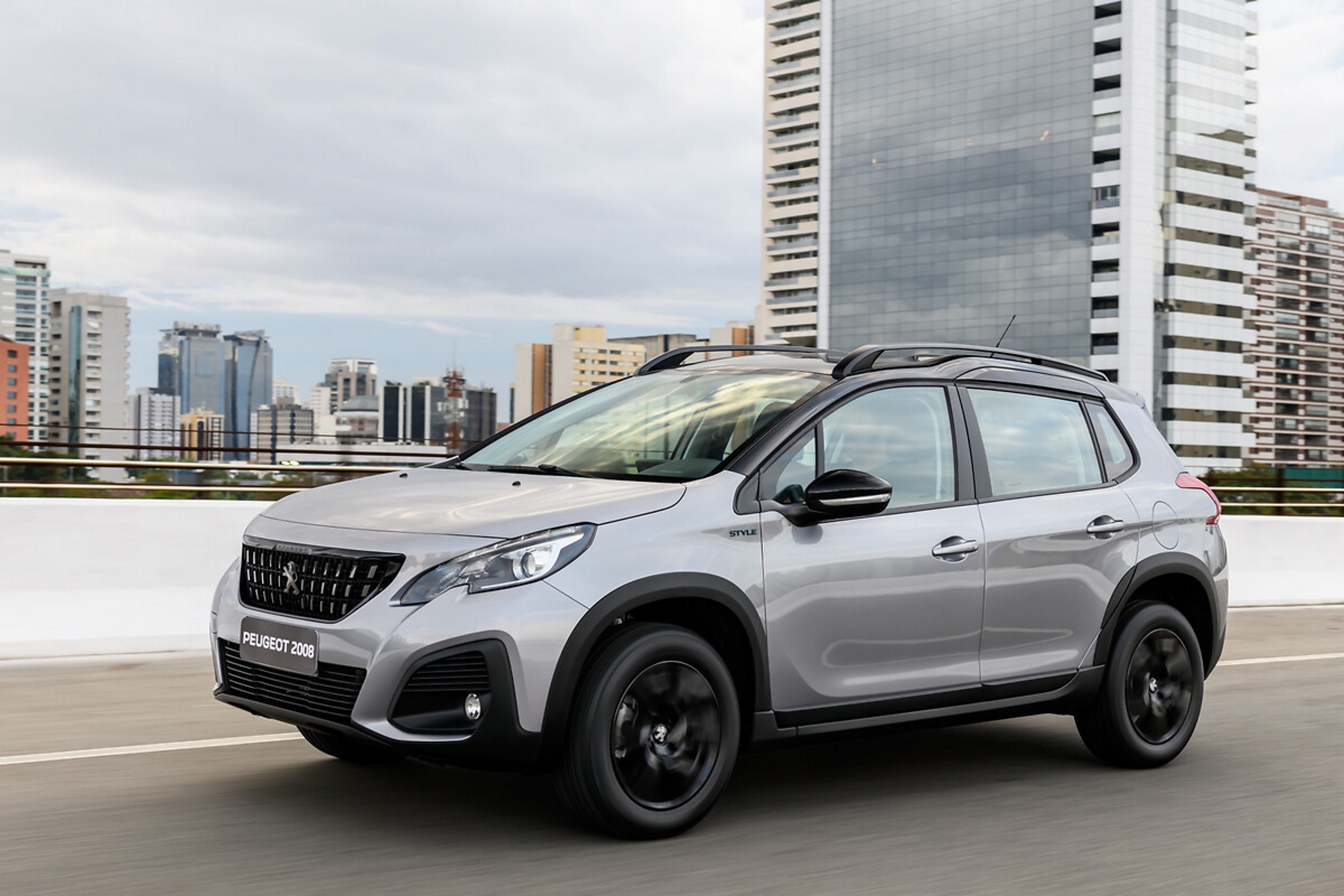 b6ea6ec7 peugeot 2008 style 1.6 thp linha 2024 cinza de frente em movimento na cidade