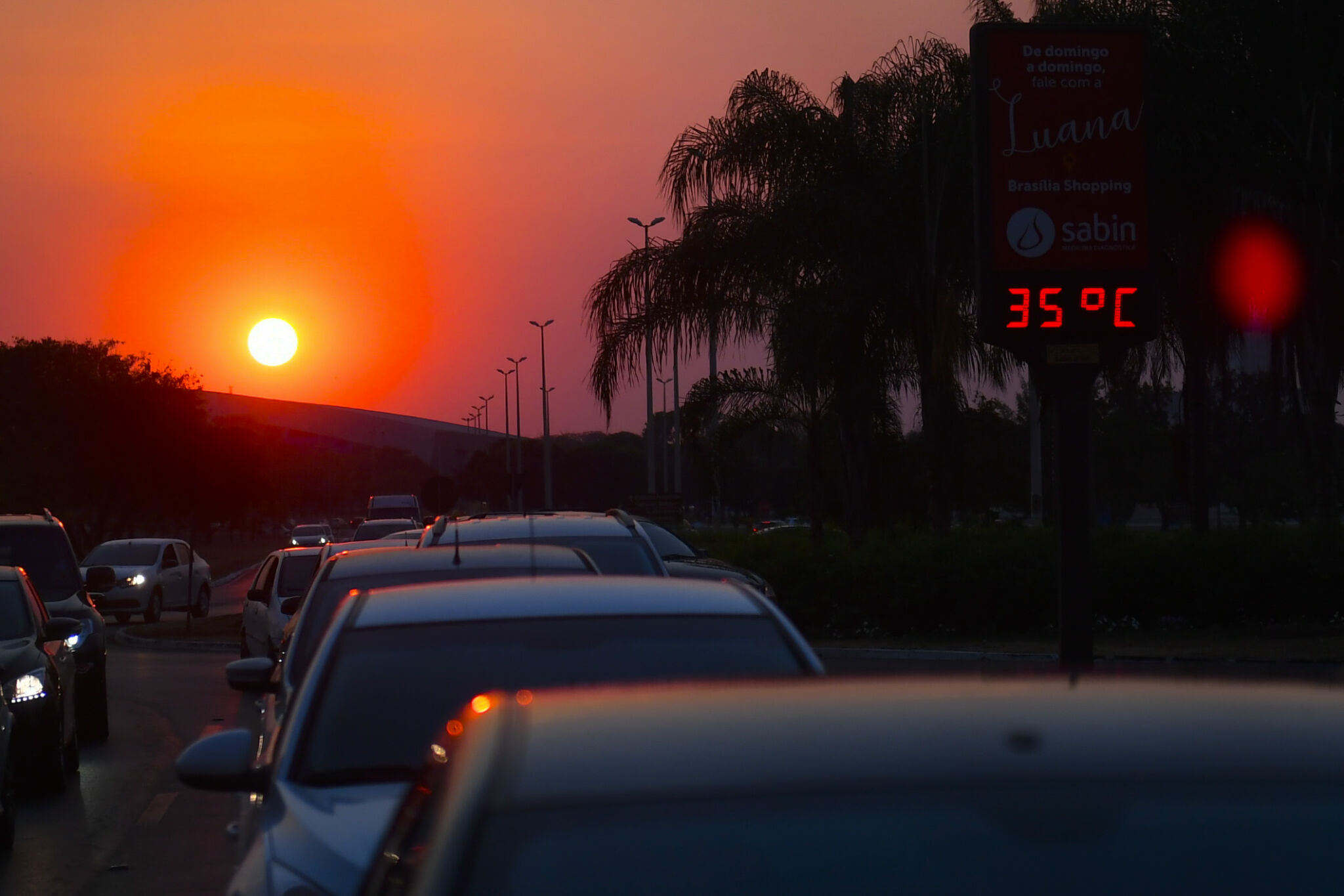 Trânsito de carros sob o sol, com um termômetro marcando 35 graus; para matéria sobre cuidados com o ar-condicionado.