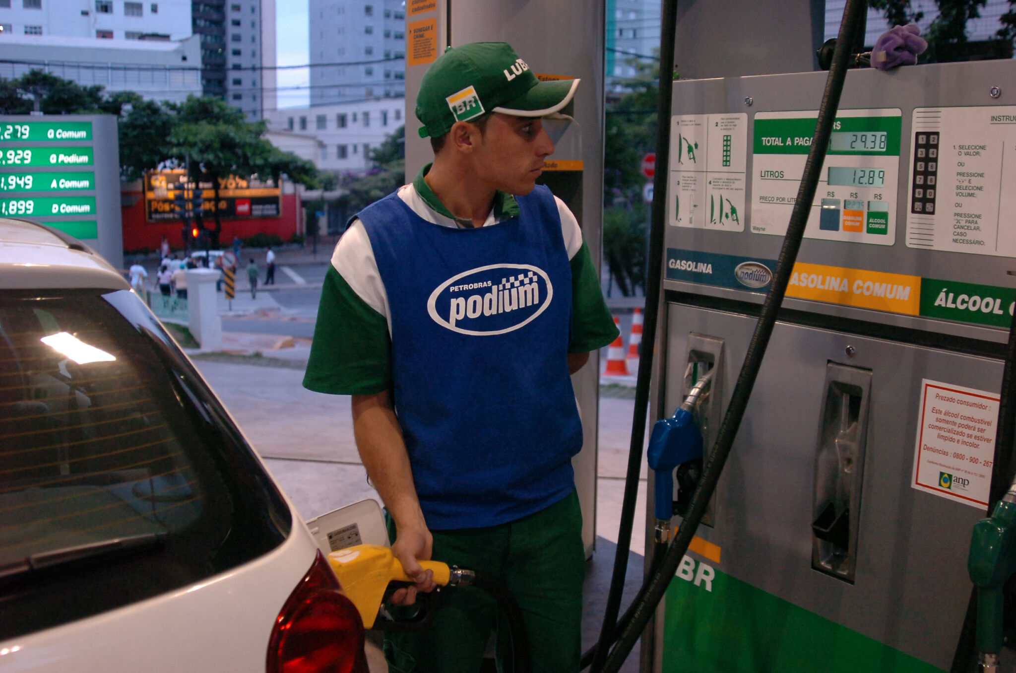 Frentista abastece automóvel com gasolina em posto de combustiveis