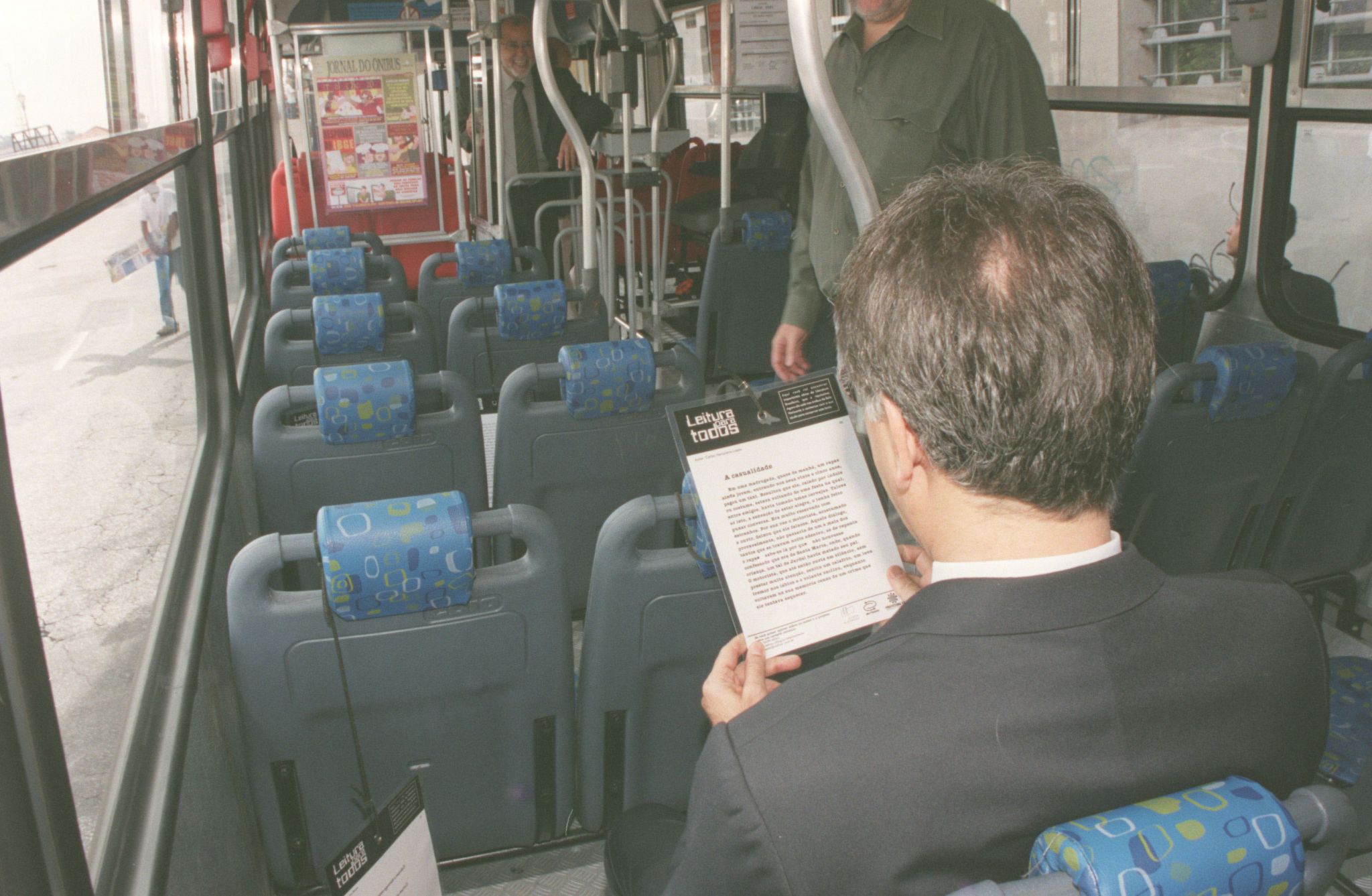 Homem lendo no ônibus, para matéria sobre carros de professor.